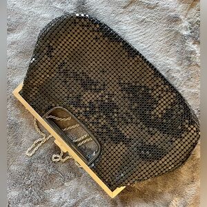 Cute clutch or shoulder bag in shiny black with a metallic strap